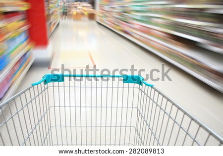 Shopping Cart View on a Supermarket Aisle and Shelves with Motion Blur