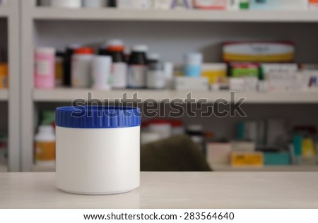 medicine bottle with pharmacy store shelves background