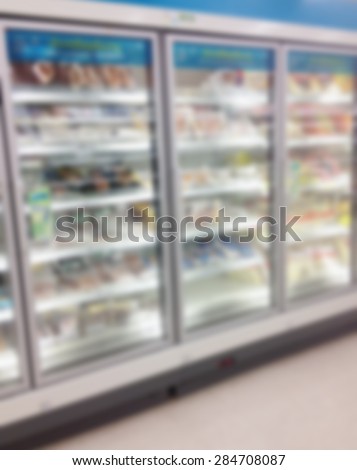 Supermarket store blur background with frozen food shelves in refrigerator