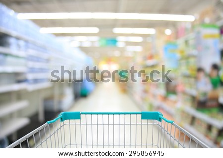 water shelves in supermarket blurred background white shopping cart