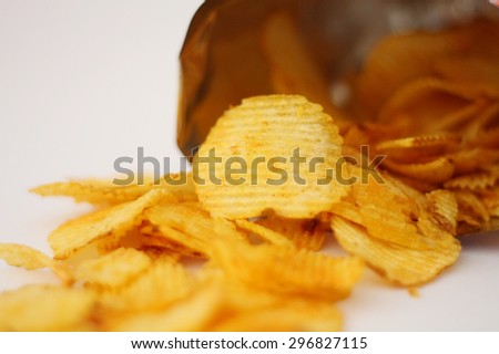 Opened pack of delicious spicy potato chips on white background
