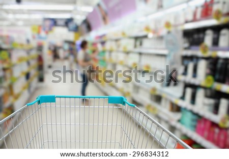 blurred health product shelves in supermarket for background with shopping cart