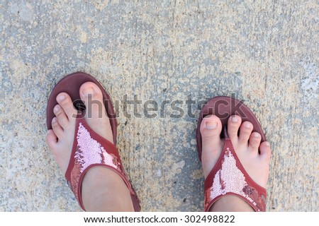 Top view of cement floor and human feet