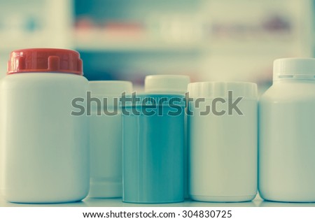 many medicine bottle with blur shelves of drug in the pharmacy drugstore background vintage filter