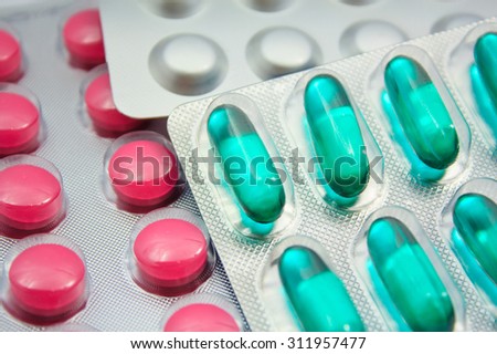 Capsules and pills packed in blisters isolated on white close-up