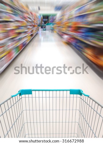 supermarket shelves aisle blurred background with shopping cart in motion