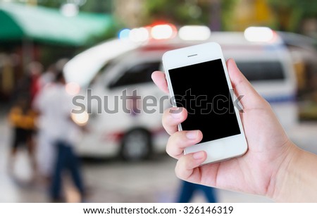 hand hold smartphone with Ambulance responding to an emergency call background