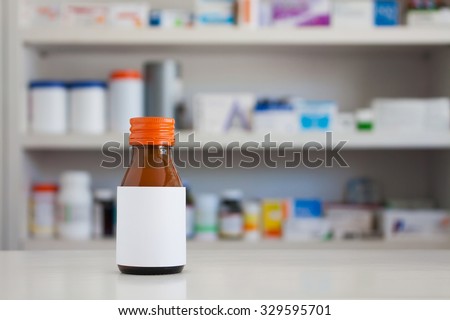 Blank white label of brown glass medicine bottle with blur shelves of drug in the pharmacy drugstore background