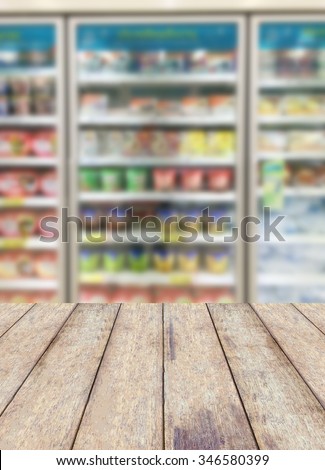 wood floor with commercial refrigerators in a large supermarket blurred background, product display concept