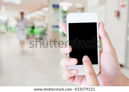 hand hold mobile smartphone with hospital interior blur medical background