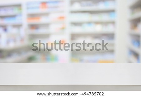 Blank white pharmacy table counter with blur shelves of drug in the pharmacy drugstore background, For create montage medical product display