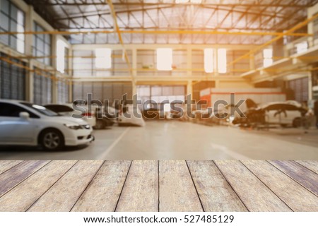 Wood table top with Car repair service centre interior blurred background. For create montage auto product display.