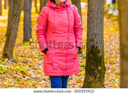young girl walking in autumn park on yellow leaves