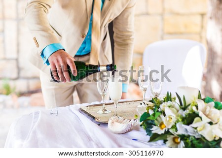 Banquet event. Man pouring champagne into glass.