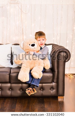 Portrait of little boy with teddy bear at home