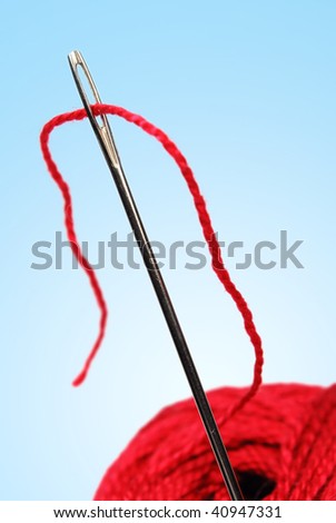 clew and needle with red thread