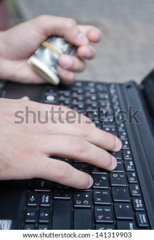 Men hands typing on a keyboard of laptop