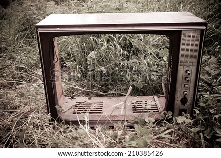 old black and white tv broken in the field, concept of retro and modern, outdoor shot