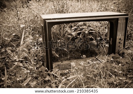 old black and white tv broken in the field, concept of retro and modern, outdoor shot