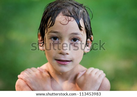 close up of a little boy all wet after cooling down on the water on a hot summer day