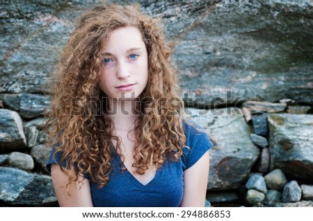 closeup of a teenage girl with freckles and long curly hair