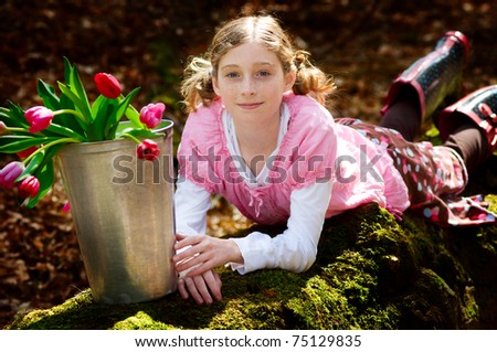 pretty tween girl with tulips outdoors in a forest