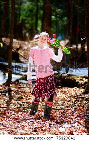 pretty tween girl with tulips outdoors in a forest
