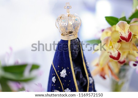Statue of the image of Our Lady of Aparecida, mother of God in the Catholic religion, patroness of Brazil, decorated with flowers and orchids
