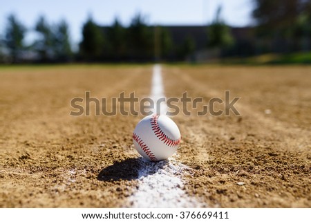 Baseball in a baseball field in California mountains on a white line