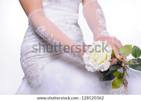 closeup hands of sitting bride with white rose