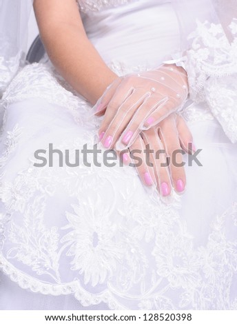 closeup hands of sitting bride wearing in wedding dress
