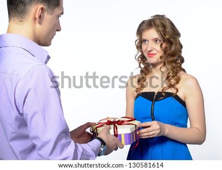 young man makes a gift to his girlfriend in blue dress