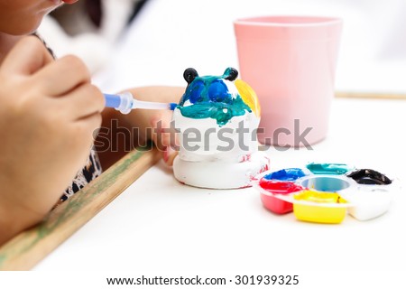 The kid painting color on the plaster statue