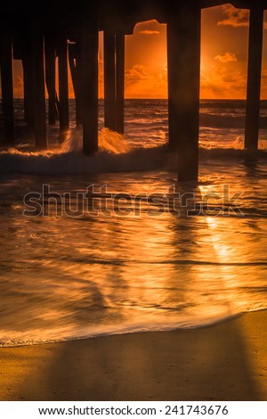 A sunset shot looking out to the Pacific Ocean under the Huntington Beach Pier.