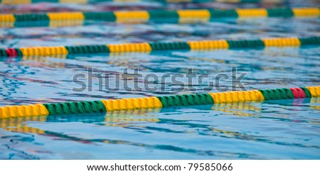 A shot of a swimming pool set for a swim meet with green and yellow lanes.