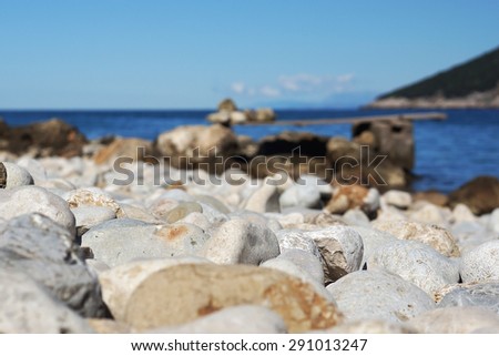 Large stone pebbles on the shore of the sea of the Bay, a small zone of sharpness, springboard