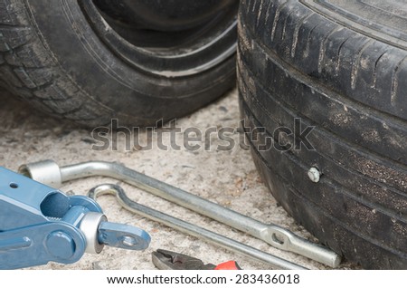 close up image of a screw nail puncturing car tire.