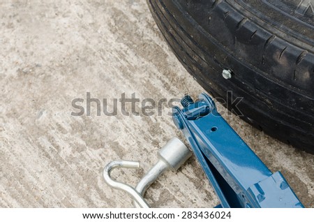close up image of a screw nail puncturing car tire