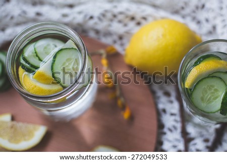 lemon cucumber infused water for diet and detox healthy body care in rustic style on wooden background