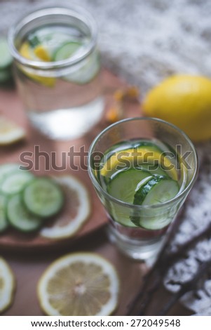 lemon cucumber infused water for diet and detox healthy body care in rustic style on wooden background