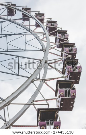 retro ferris wheel over blue skies during daytime holiday leisure time activity with family at the festival