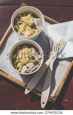 street food festival super tasty noodles pasta with chi?ken sau?e and cheese italian cuisine meal on a wood background and wooden forks
