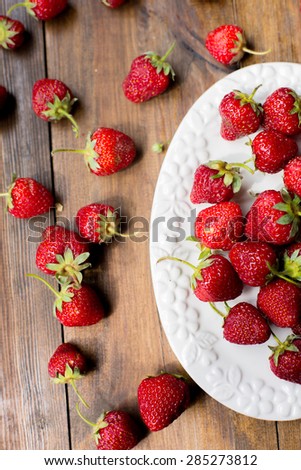 organic fresh sweet strawberries as a seasonal breakfast in the morning right from farmers market on dark wood table background decorated in rustic style
