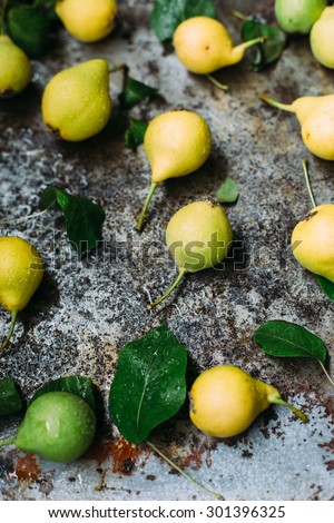 organic green and yellow pears from farmers market on aged background rustic style natural light overhead shot
