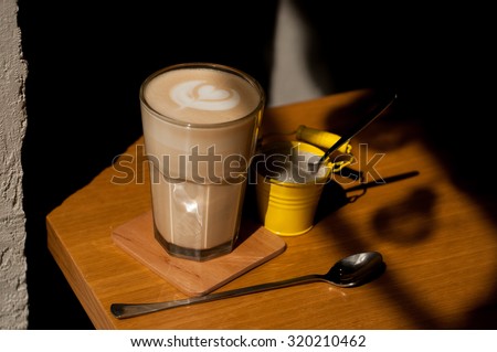 latte with sugar on the side on wood table background overhead view cool shadows natural light