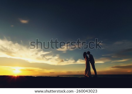 Wedding couple in Cuba in silhouettes, on background of sunset and sky