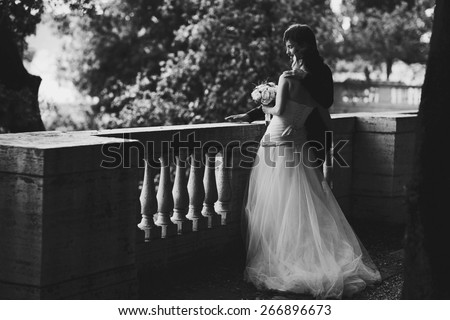 gentle beautiful bride and groom holding hands hugging near the ancient fence balcony Roma Italy black and white