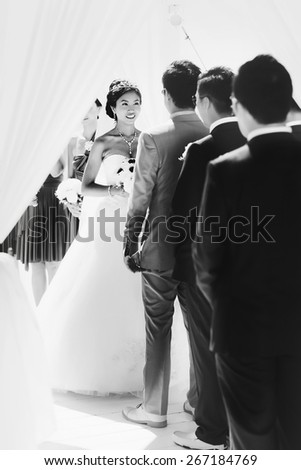 stylish rich smiling asian bride and groom  wedding look at each other in island Santorini greece sunshine black and white