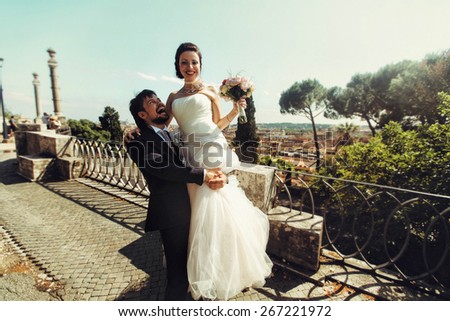 gentle rich stylish  groom holds bride on the terrace on the background of cityscape of Rome Italy on a sunny day