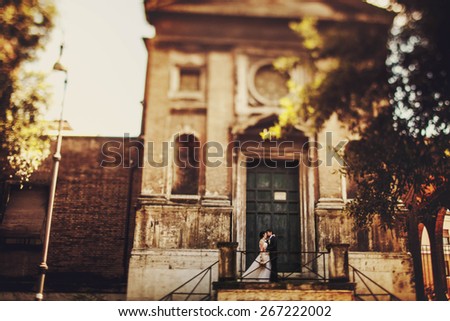 wonderful stylish rich couple kissing hugging on the background  old castle door and Rome Italy